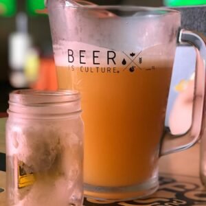 beverage filled pitcher beside empty jar