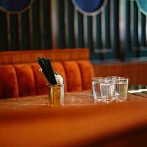clear drinking glass beside silver fork and knife on brown wooden table